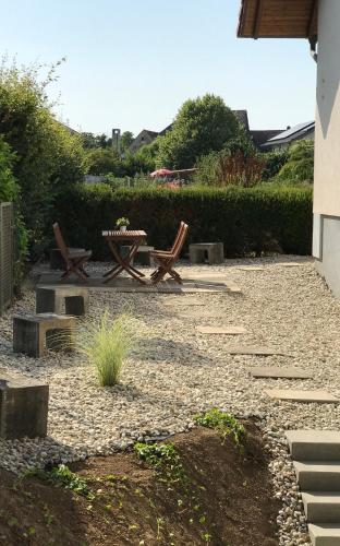 a patio with two chairs and a table in a yard at Casa Blanca 1 in Schwanau