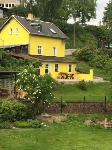 a yellow house with a picnic table in front of it at Ferienhaus Sandy in Bad Elster