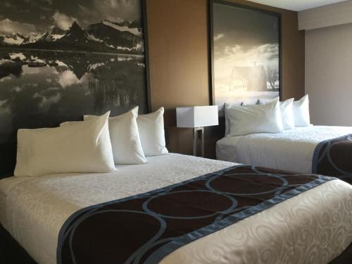 a hotel room with two beds and a painting on the wall at Super 8 by Wyndham Spruce Grove in Spruce Grove