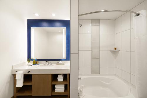 a bathroom with a tub and a sink and a shower at Ayres Hotel San Diego South - Chula Vista in Chula Vista