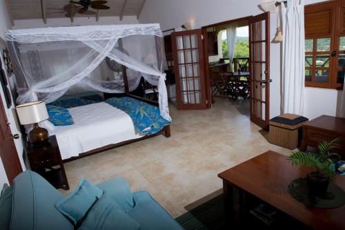 a bedroom with a bed and a living room at Villa Touloulou in English Harbour Town