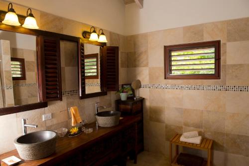 a bathroom with two sinks and a mirror at Villa Touloulou in English Harbour Town