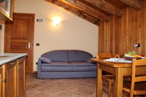 a living room with a blue couch in a kitchen at Family Apartments Le Chalet in Champoluc