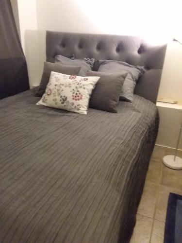 a large bed with a gray headboard and pillows at Grebbestad in Grebbestad