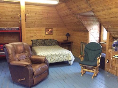 a bedroom with a bed and a chair in a room at Domaine Montauban in Saint Fortunat