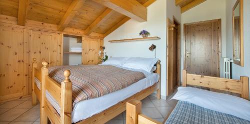 a bedroom with a bed in a room with wooden walls at Hotel Gallo Cedrone in Valdisotto