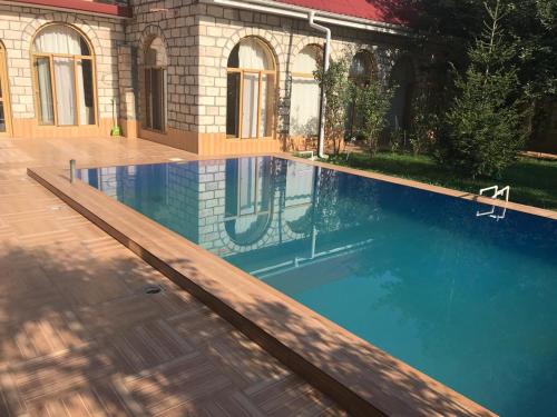 a swimming pool in front of a house at Sheki Apartments in Sheki