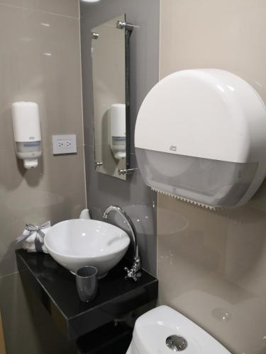 a bathroom with a white sink and a toilet at Apartments and Rooms Distecon in Guatemala