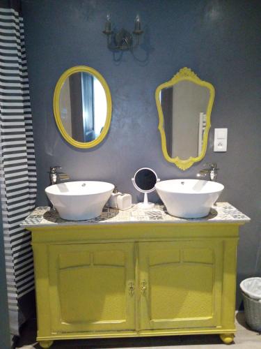 La salle de bains est pourvue de 2 lavabos et de miroirs sur un comptoir. dans l'établissement appartement Vintage a l ancienne forge, à Muhlbach-sur-Munster