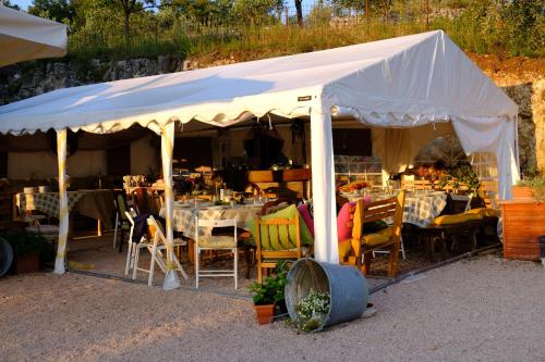 ヴェローナにあるAgriturismo MACOLE Fattoria con Spuntiniの白いテント(テーブル、椅子付)