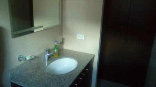 y baño con lavabo y espejo. en Carolina Family Suite, en Quito