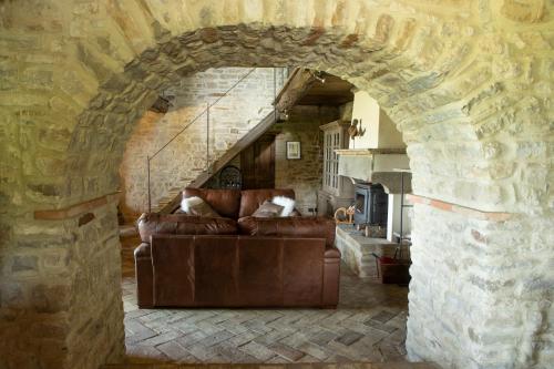 a living room with a couch in a stone wall at Il Monte in Pietralunga