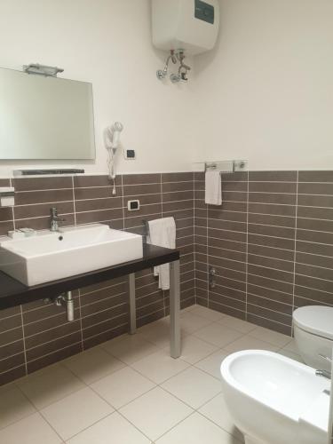 a bathroom with a sink and a toilet and a mirror at Aparthotel Por do Sol in Sal Rei