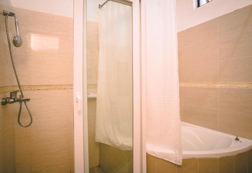 a shower with a white shower curtain in a bathroom at High Ground Villa Ltd in Kigali