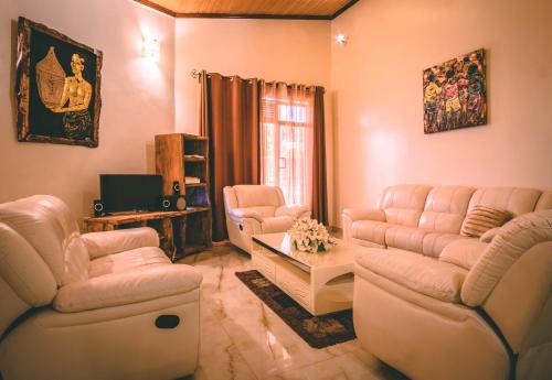 a living room with two couches and a tv at High Ground Villa Ltd in Kigali
