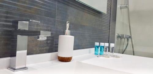 a bathroom sink with a bottle of soap and toothbrushes at CHINASOLYMAR LUXURY - Con Parking in Almuñécar