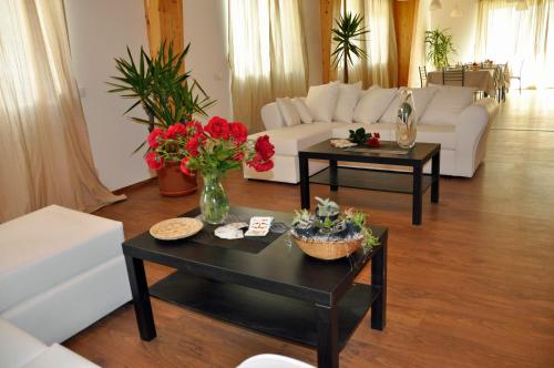 a living room with a white couch and tables with flowers at LUNAR room & breakfast in Borgo