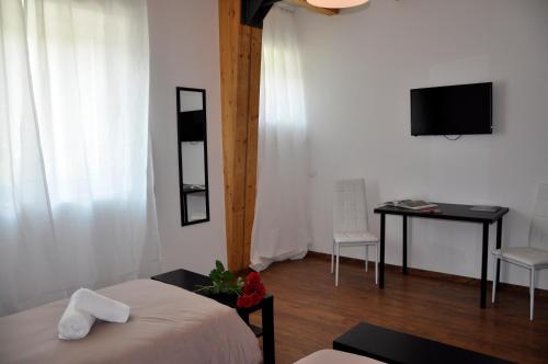 1 dormitorio con cama, mesa y TV en LUNAR room & breakfast, en Borgo