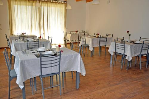 una habitación con mesas y sillas con mantel blanco en LUNAR room & breakfast, en Borgo
