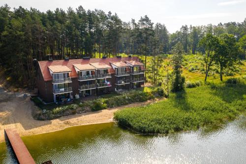 an aerial view of a building next to a body of water at Apartamenty Mazurskie Klimaty (Cud Natury) in Tomaszkowo