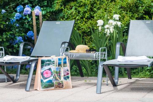 two chairs and a table and a picnic table with a book at Hotel & Spa Cacciatori in Cademario