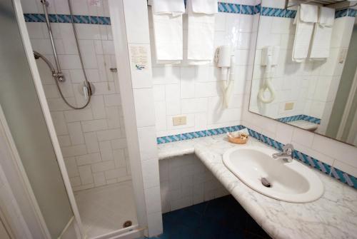 y baño con lavabo y ducha. en Hotel Residence Isola Verde en Marciana Marina