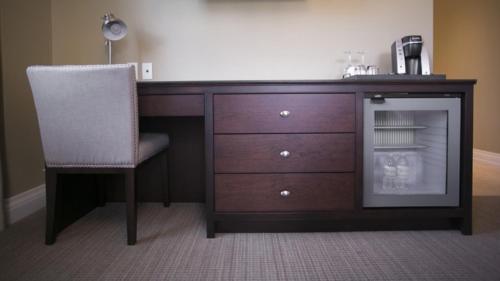 a desk with a chair next to a dresser at 124 on Queen Hotel & Spa in Niagara on the Lake