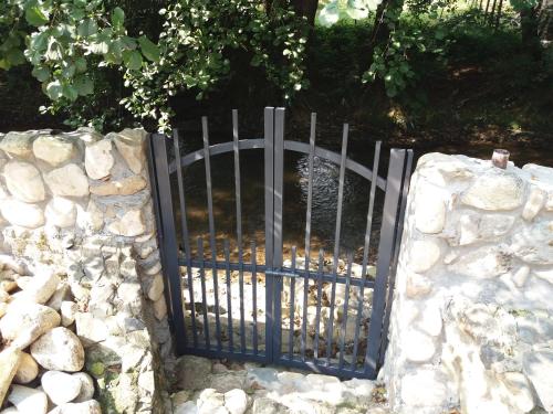 a gate in a stone wall with a fountain at Guesthouse Silvani in Kruševac