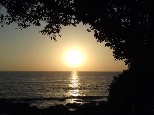 a sunset over the ocean with the sun in the sky at Coco Loco Lodge in El Valle