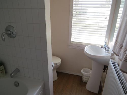 een witte badkamer met een wastafel en een toilet bij Burns Lake Bed and Breakfast in Burns Lake