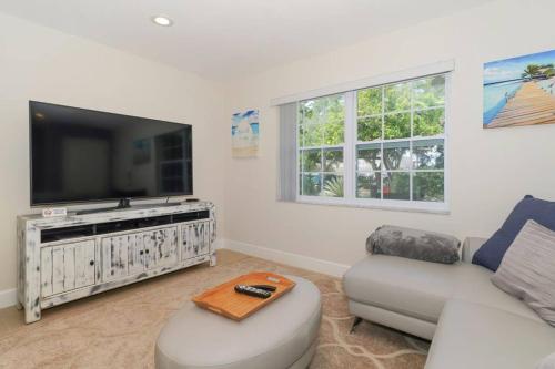 a living room with a couch and a flat screen tv at Lovely Cottage - Close to Siesta, Shops & Dining in Sarasota