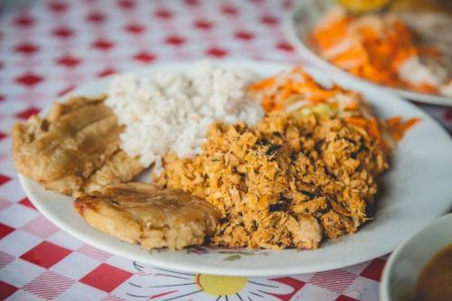 a plate of food on a table with rice and meat at Coco Loco Lodge in El Valle