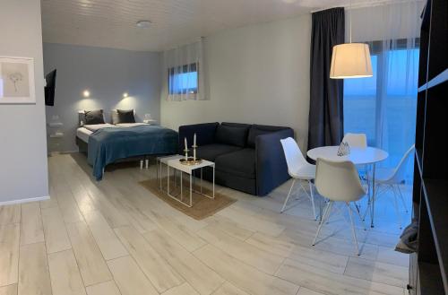 a living room with a couch and a bed and a table at Heima Holiday Homes in Selfoss