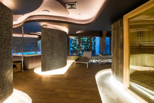 a room with a tub with a chair and some windows at Hotel Termas Chillán in Nevados de Chillan