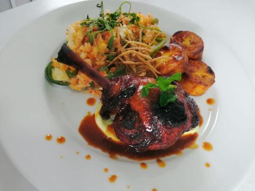 a white plate of food with meat and potatoes at Hotel WLH Silver Corferias in Bogotá