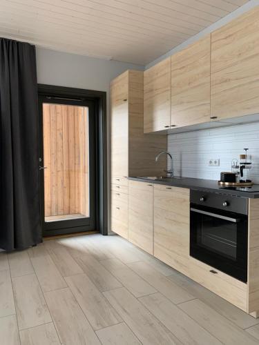 a kitchen with wooden cabinets and a black oven at Heima Holiday Homes in Selfoss