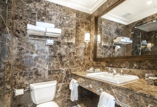 a bathroom with a toilet and a sink and a mirror at el PRADO in Palo Alto