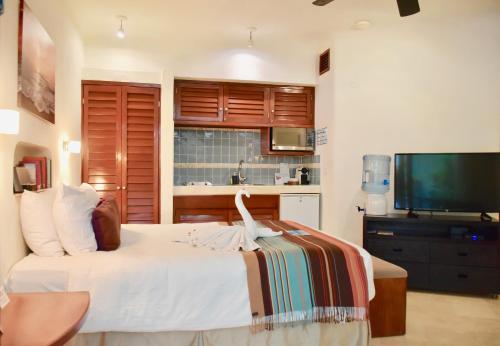 a bedroom with a bed and a flat screen tv at Playa Palms Beach Hotel in Playa del Carmen