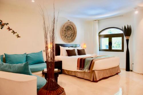 a bedroom with a bed and a couch at Playa Palms Beach Hotel in Playa del Carmen