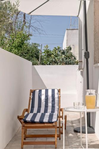 a chair and a table on a patio with an umbrella at Casa Te Mare in Torre Suda