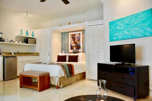 a bedroom with a bed and a flat screen tv at Playa Palms Beach Hotel in Playa del Carmen