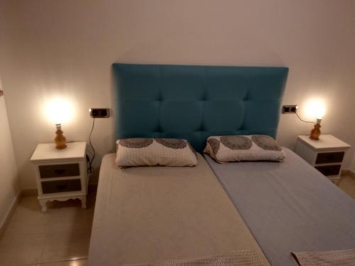 ベニドルムにあるThe apartment Beniardáの青いヘッドボード付きの大型ベッド1台が備わる客室です。