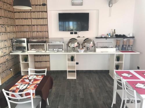 a kitchen with a counter with a table and chairs at Aparthotel Por do Sol in Sal Rei
