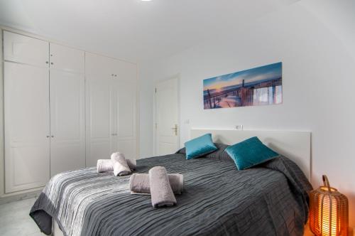 une chambre avec un grand lit avec des oreillers bleus dans l'établissement LA ESTRELLA 1A020, à Los Cristianos