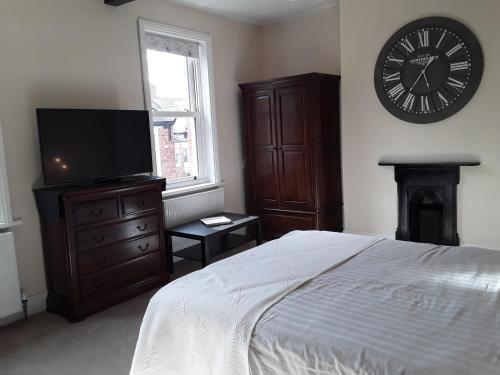 a bedroom with a bed and a clock on the wall at The Haven in Gateshead