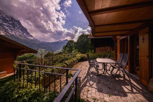 a balcony with a table and chairs and mountains at Bisi in Grindelwald