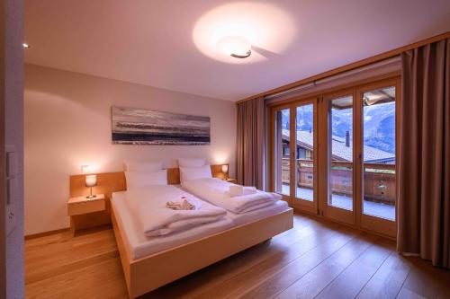 een slaapkamer met een bed en een groot raam bij Bisi in Grindelwald