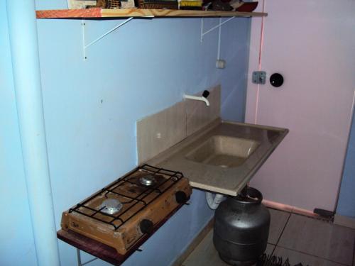 a kitchen with a stove and a sink at Suíte na Serra in São Roque de Minas