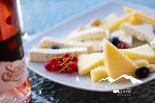 a plate of cheese and fruit on a table at Vila Alpin in Straja