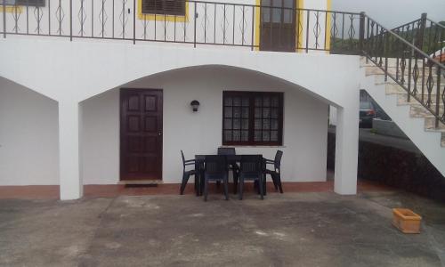 a black table and chairs in a courtyard with a staircase at Casa da Sogra - Apartamento 3 in Faja Grande